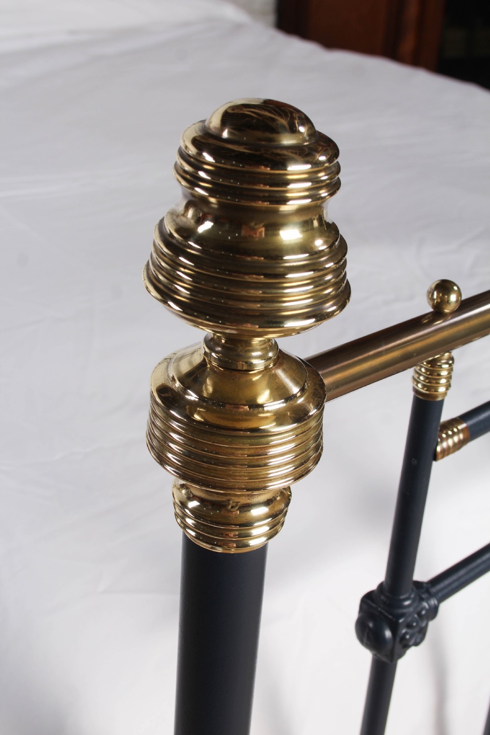 A Victorian king size bedstead crafted from black iron with polished brass rails, finials, and a central circular brass motif. View VIII