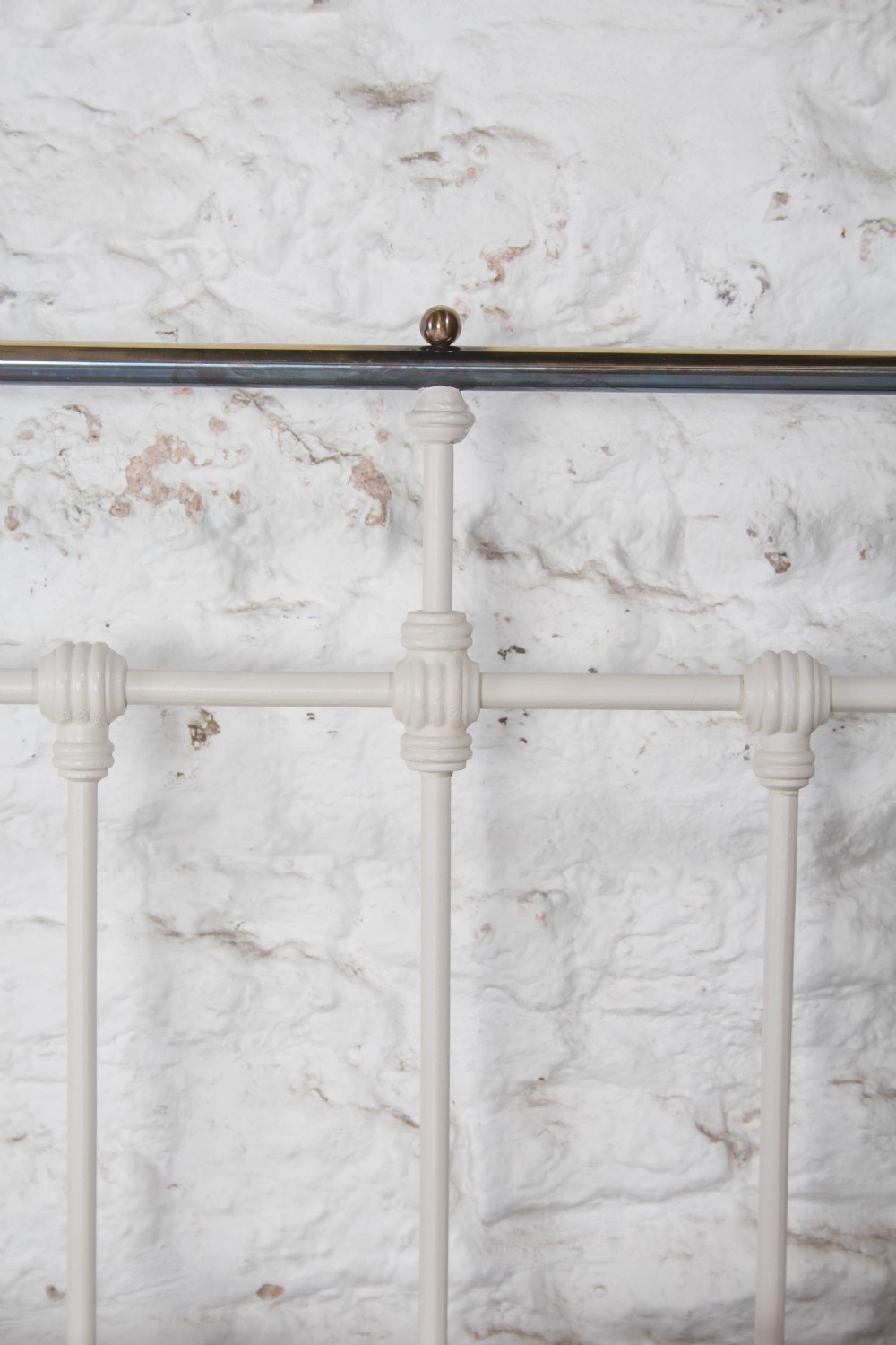 A pair of white painted Victorian single bed frames with vertical iron spindles and brass top rails. View VI