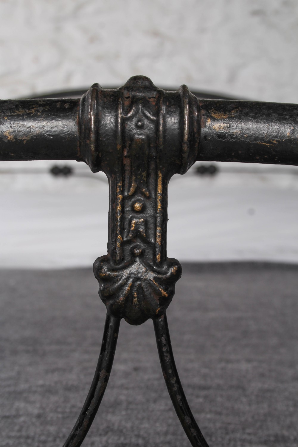 An antique dark wrought iron double bed frame featuring arched headboard and footboard rails with decorative cast rosettes. View IV