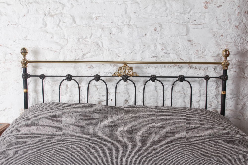 A Victorian five-foot king-size bedstead featuring a black japanned cast iron frame with vertical arched spindles, central diamond motifs, and brass top rails with brass finials. View III