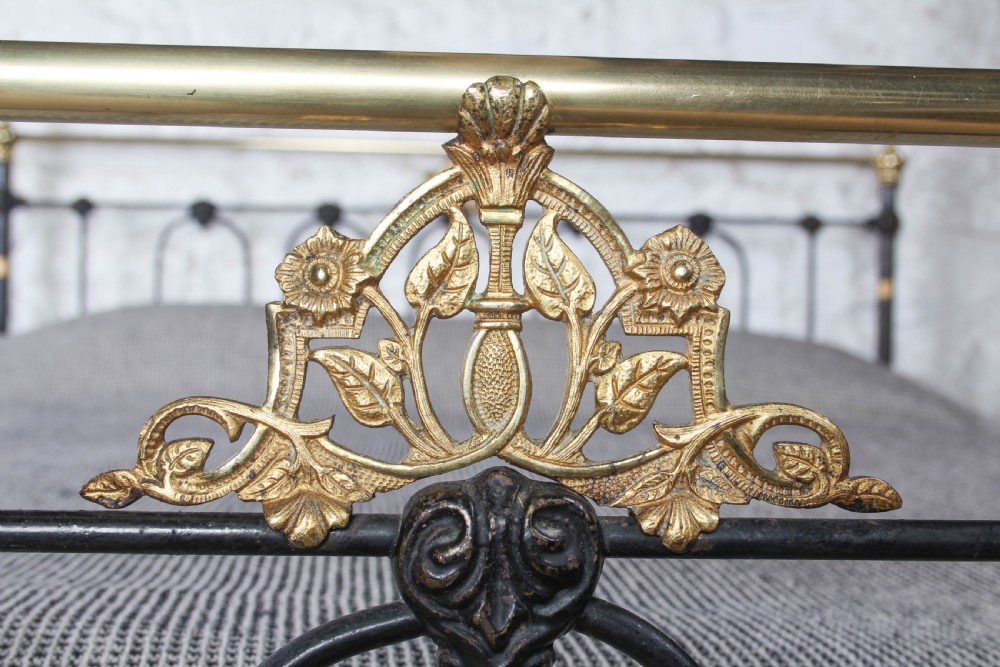 A Victorian five-foot king-size bedstead featuring a black japanned cast iron frame with vertical arched spindles, central diamond motifs, and brass top rails with brass finials. View IV