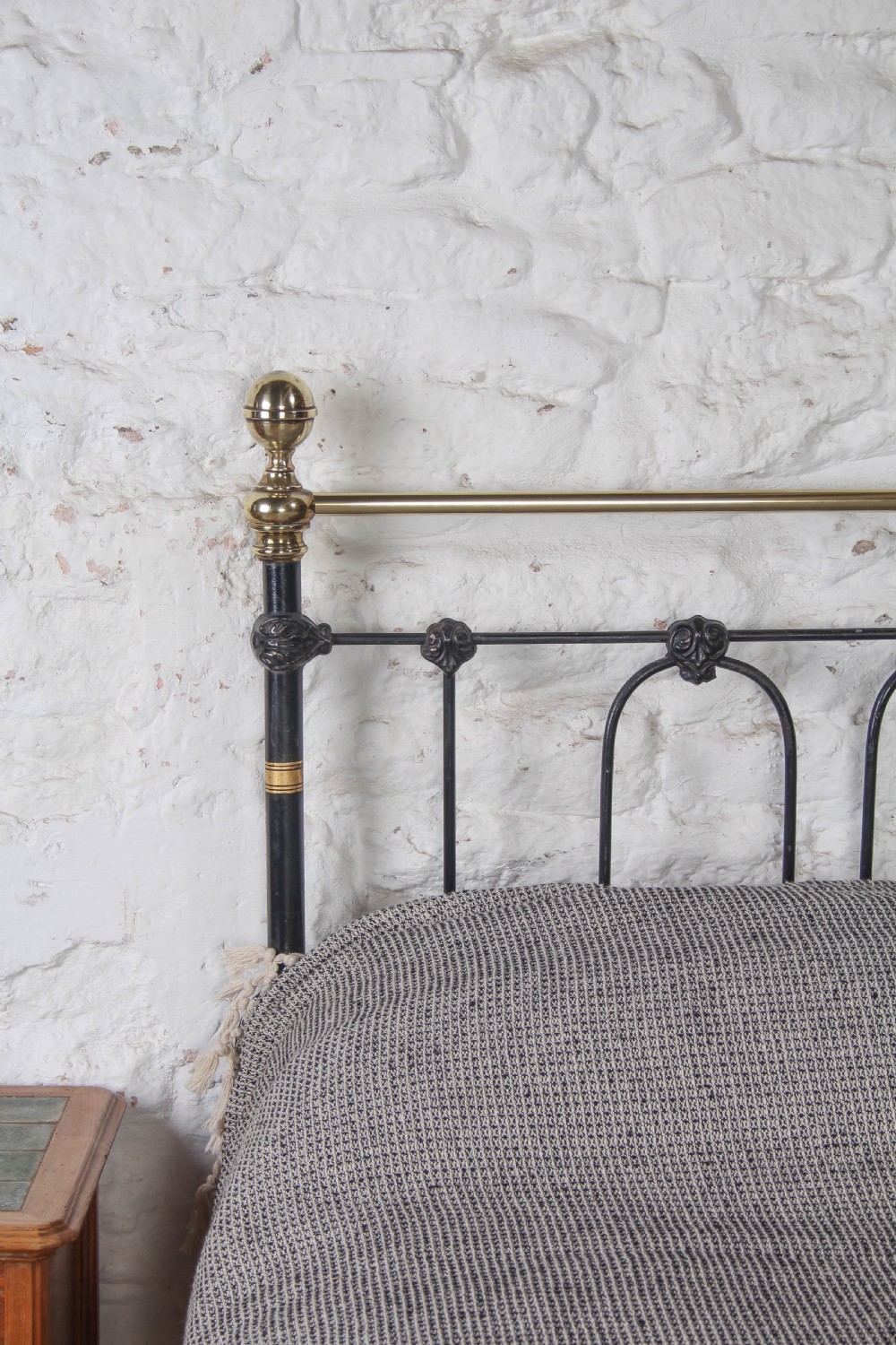 A Victorian five-foot king-size bedstead featuring a black japanned cast iron frame with vertical arched spindles, central diamond motifs, and brass top rails with brass finials. View VIII