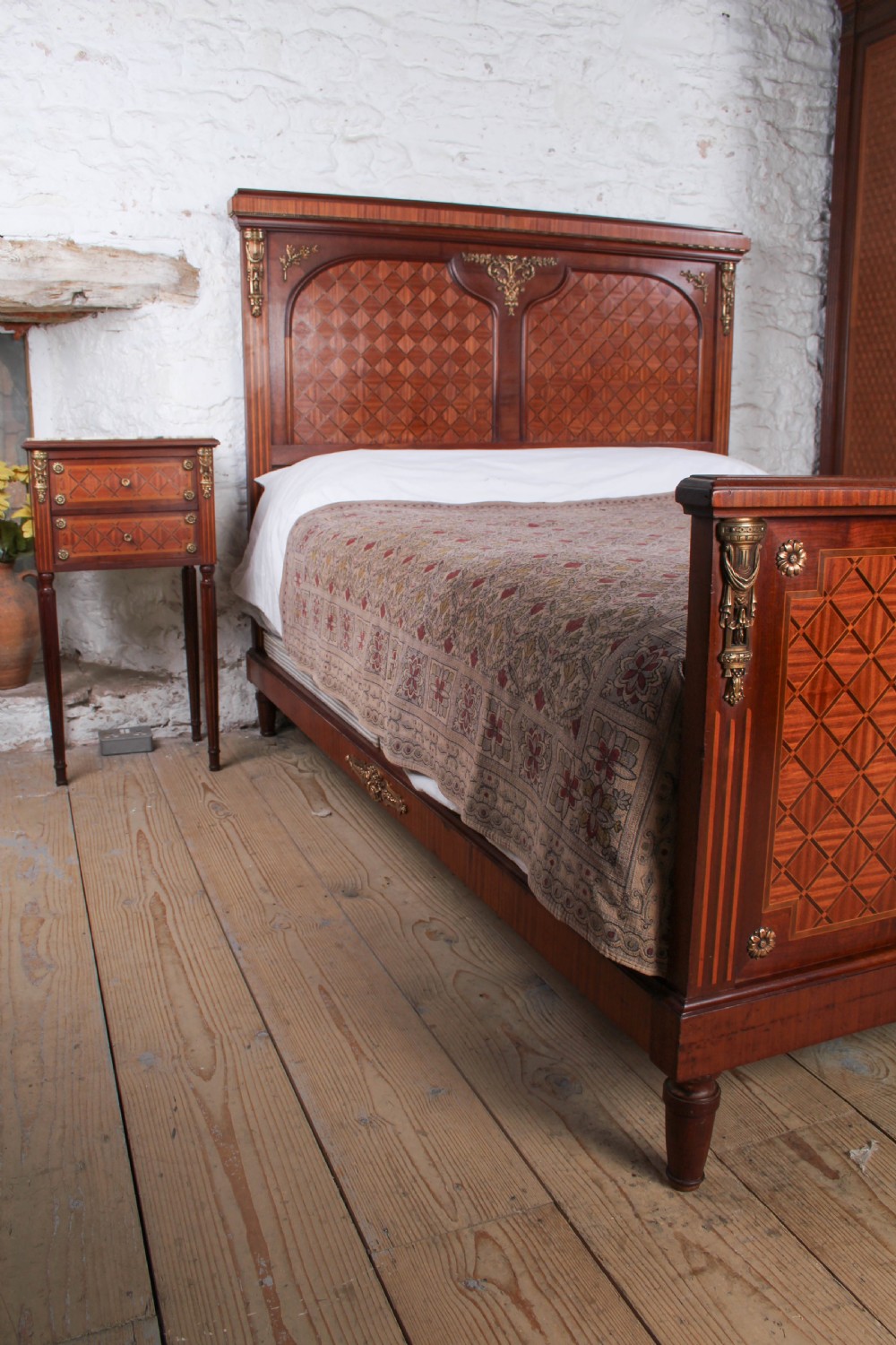 A French Empire style king size bed frame crafted from mahogany with diamond geometric fruitwood parquetry inlays and decorative brass mounts. View II