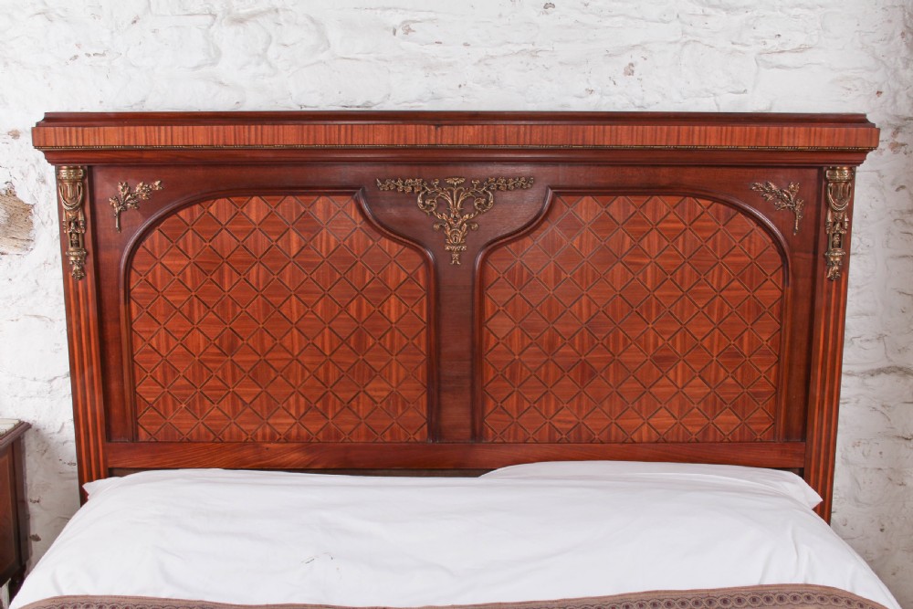 A French Empire style king size bed frame crafted from mahogany with diamond geometric fruitwood parquetry inlays and decorative brass mounts. View III