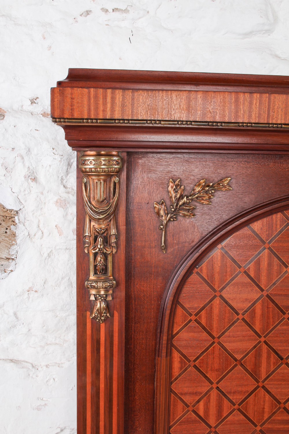 A French Empire style king size bed frame crafted from mahogany with diamond geometric fruitwood parquetry inlays and decorative brass mounts. View V