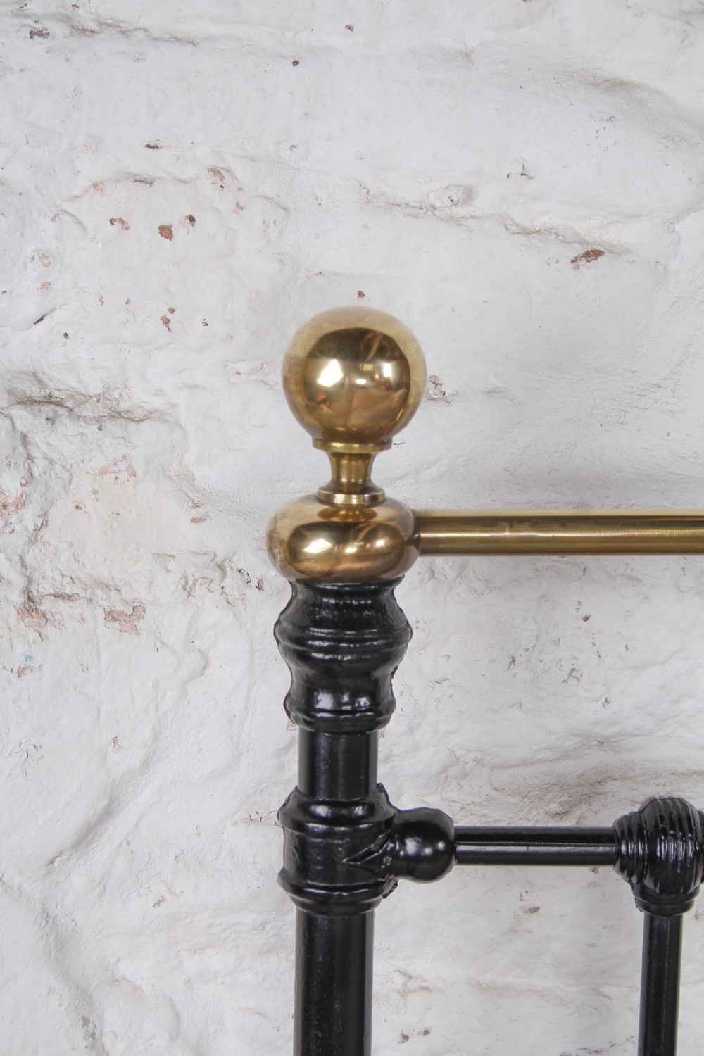 A Victorian double bedstead featuring a black painted cast iron frame, brass top rails, and spherical brass finials. View XI