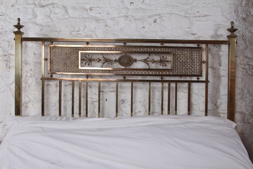 An antique French brass double bed frame with ornamental lattice headboard and footboard panels, vertical spindles, and finial corner posts. View XX