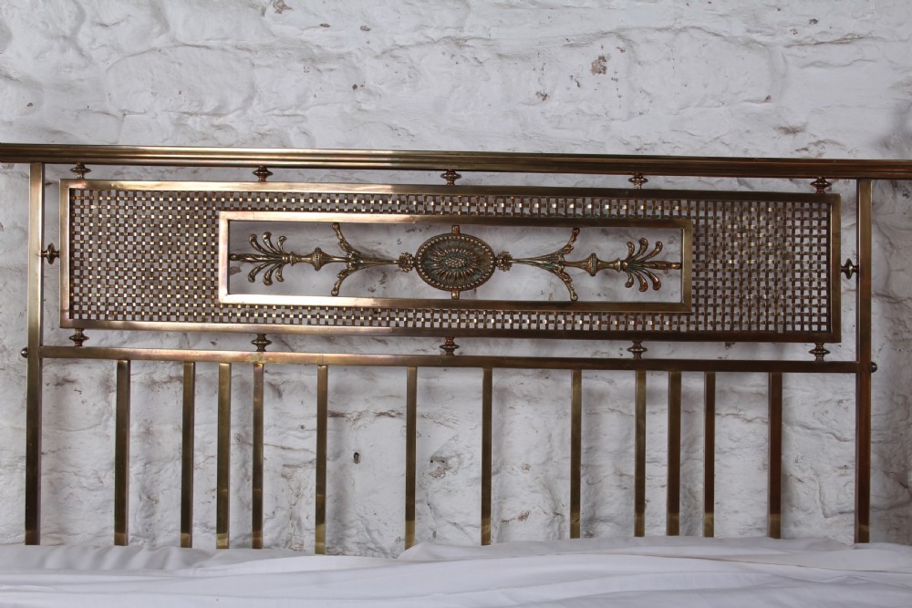 An antique French brass double bed frame with ornamental lattice headboard and footboard panels, vertical spindles, and finial corner posts. View XXI