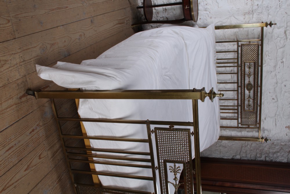 An antique French brass double bed frame with ornamental lattice headboard and footboard panels, vertical spindles, and finial corner posts. View XXII