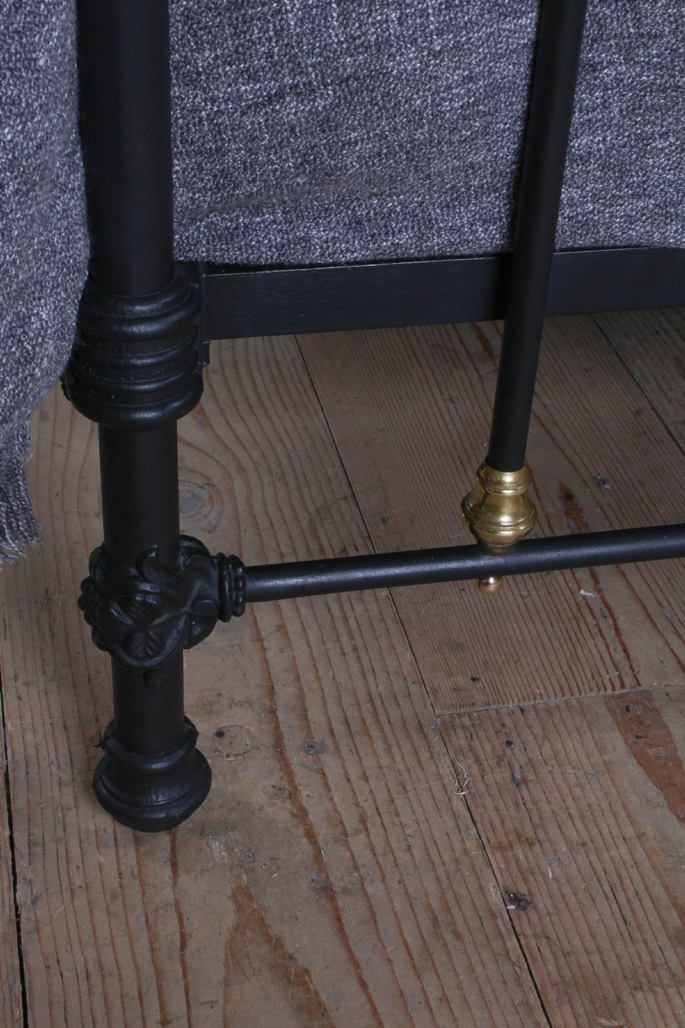 A king size black painted iron bedstead featuring rounded top rails, vertical tubular spindles, and decorative brass finials. View V