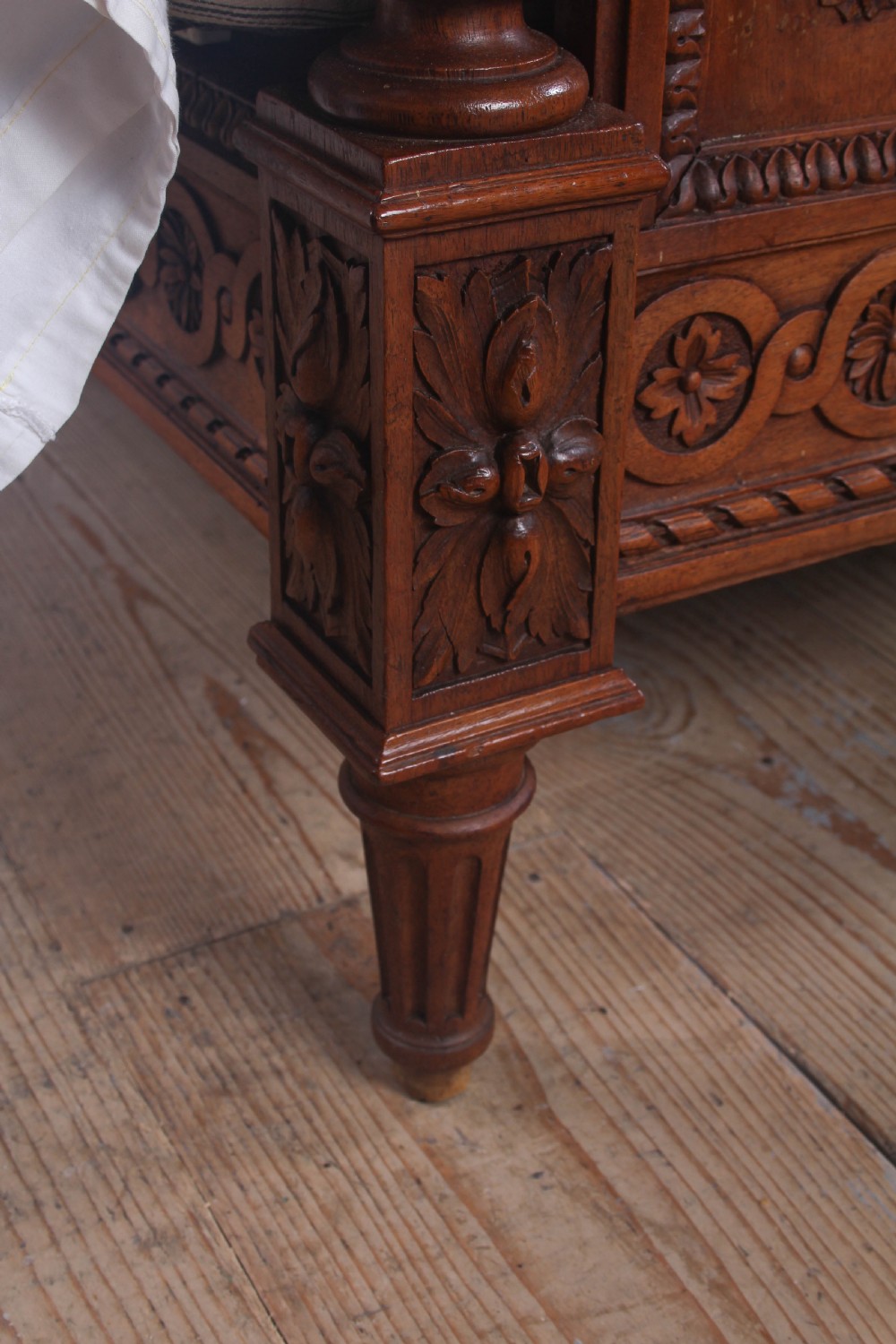 A carved walnut king-size bedstead featuring an arched headboard and footboard framed by fluted corner posts and decorative finials. View VI