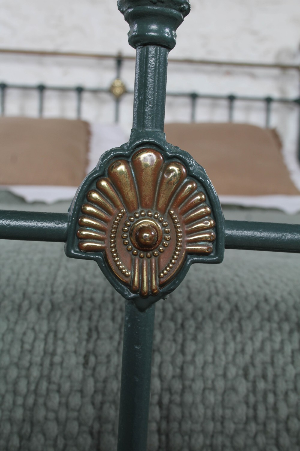 A Victorian metal bedstead featuring dark green painted iron uprights, vertical spindles, brass top rails, and brass finials. View VII