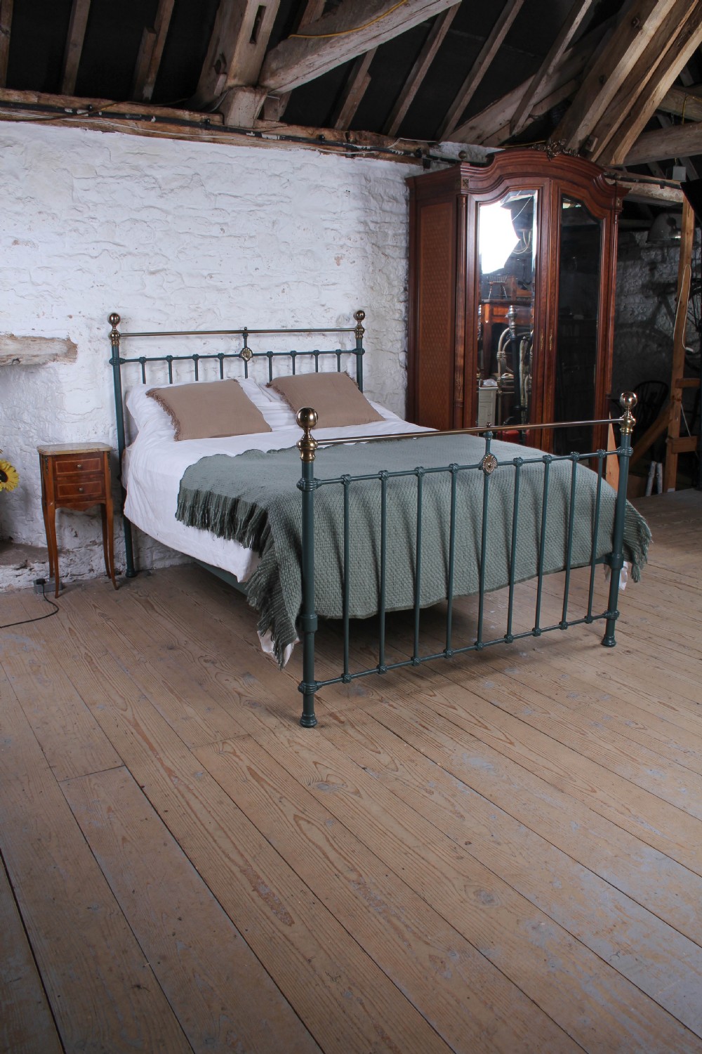 A Victorian metal bedstead featuring dark green painted iron uprights, vertical spindles, brass top rails, and brass finials. View VIII