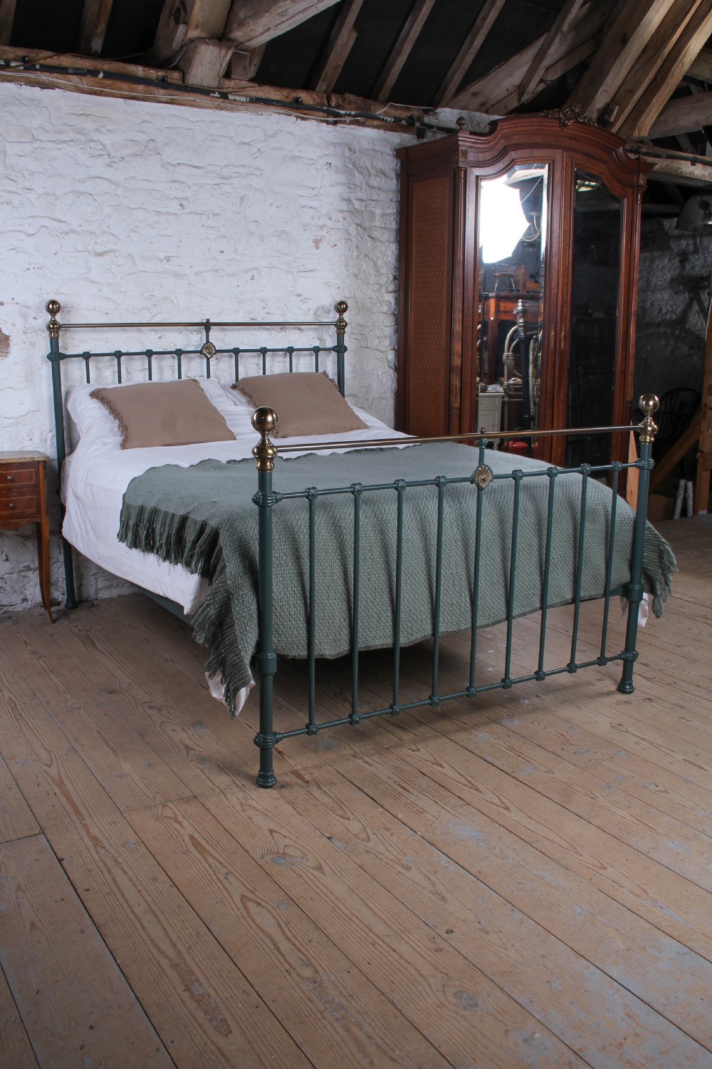 A Victorian metal bedstead featuring dark green painted iron uprights, vertical spindles, brass top rails, and brass finials. View IX