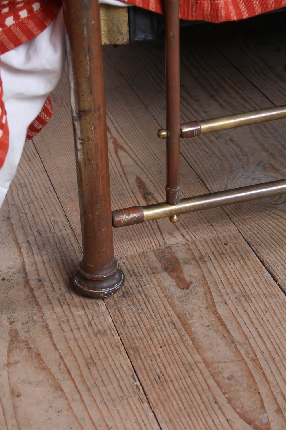 An antique brass king-size bedstead with vertical spindles, rounded tubular top rails, and cast iron corner connections. View V