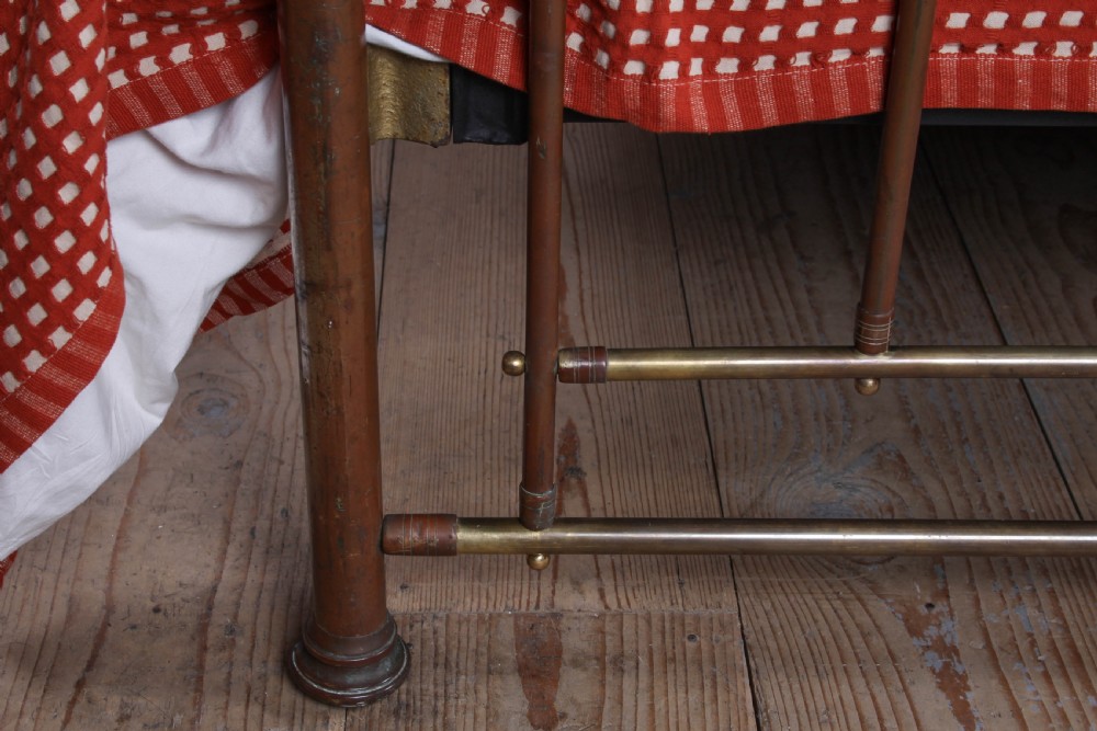 An antique brass king-size bedstead with vertical spindles, rounded tubular top rails, and cast iron corner connections. View VIII