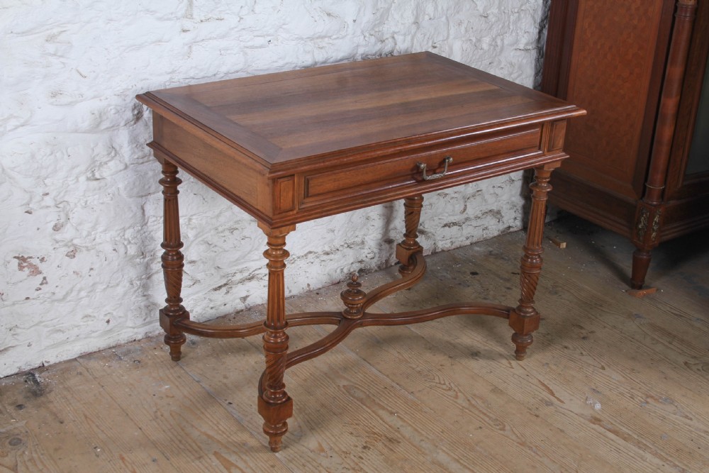 A Louis XVI style fruitwood table featuring a single frieze drawer with brass handle, turned fluted legs, and an X-frame stretcher with a central finial. View II