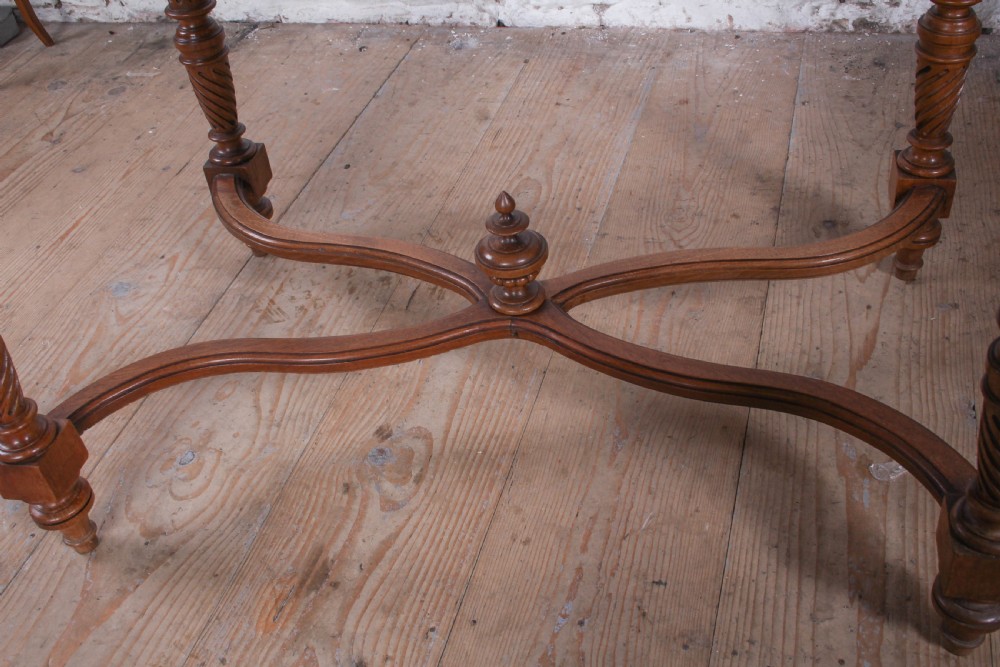 A Louis XVI style fruitwood table featuring a single frieze drawer with brass handle, turned fluted legs, and an X-frame stretcher with a central finial. View V