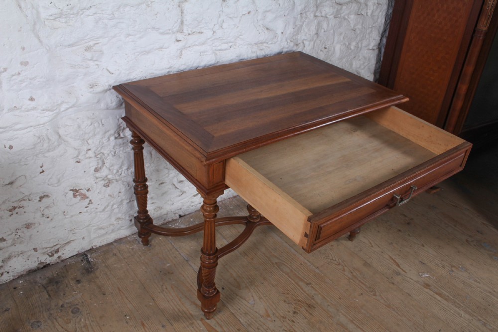 A Louis XVI style fruitwood table featuring a single frieze drawer with brass handle, turned fluted legs, and an X-frame stretcher with a central finial. View VII