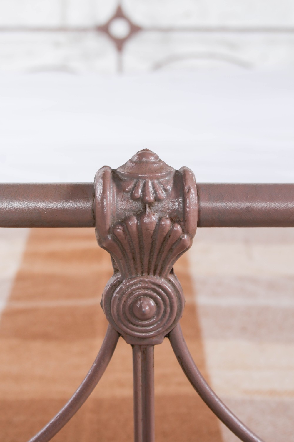An antique Irish double bed frame constructed from painted iron with curved metal scrollwork and decorative cast medallions. View IV