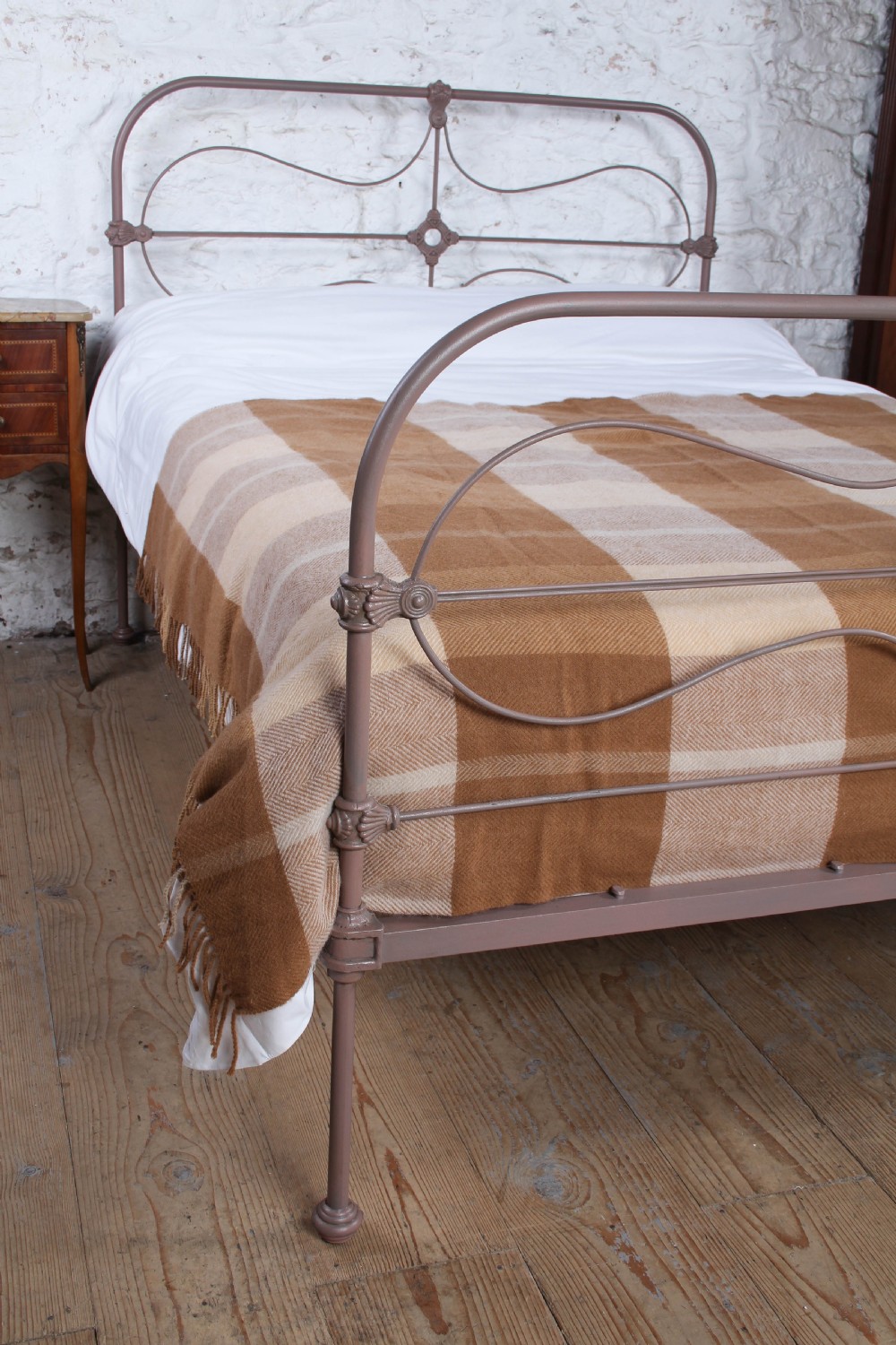 An antique Irish double bed frame constructed from painted iron with curved metal scrollwork and decorative cast medallions. View VI