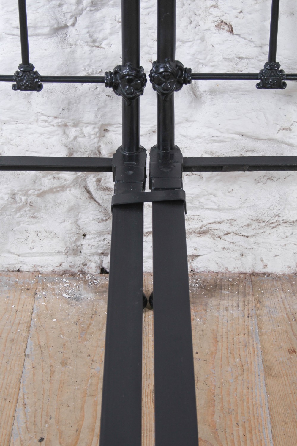 A pair of black wrought iron French single bed frames featuring vertical spindles with cast decorative rosettes and no footboards. View IX