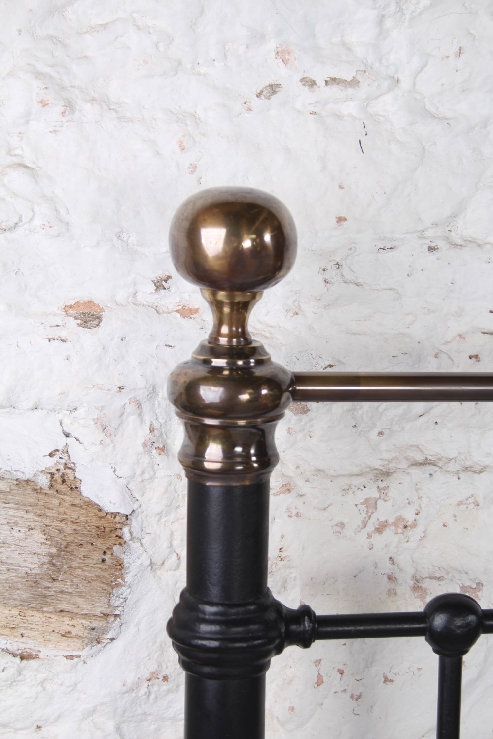 A super king size black iron bed frame featuring vertical spindles, a brass top rail, and round brass finials. View IV