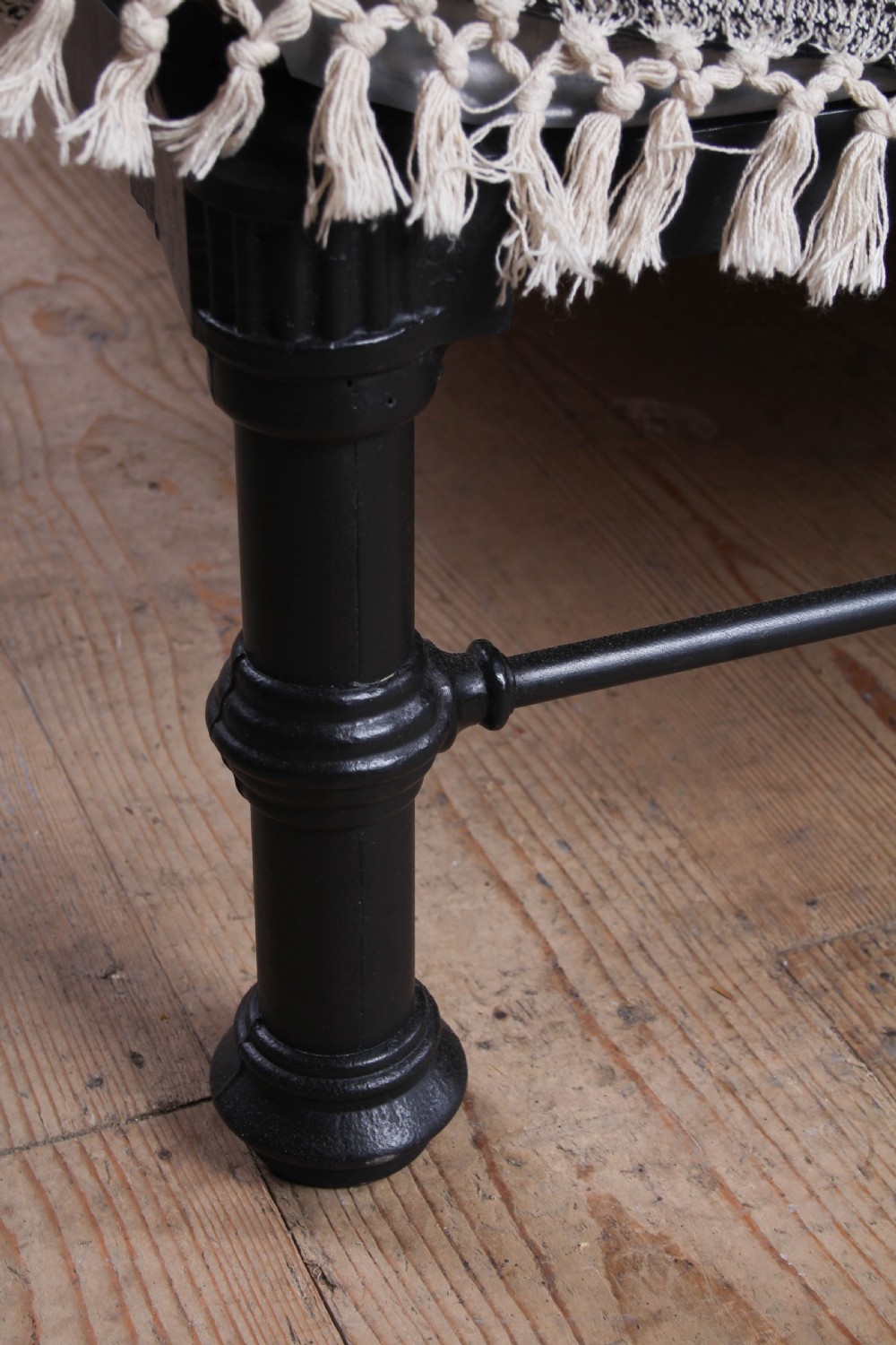 A super king size black iron bed frame featuring vertical spindles, a brass top rail, and round brass finials. View V