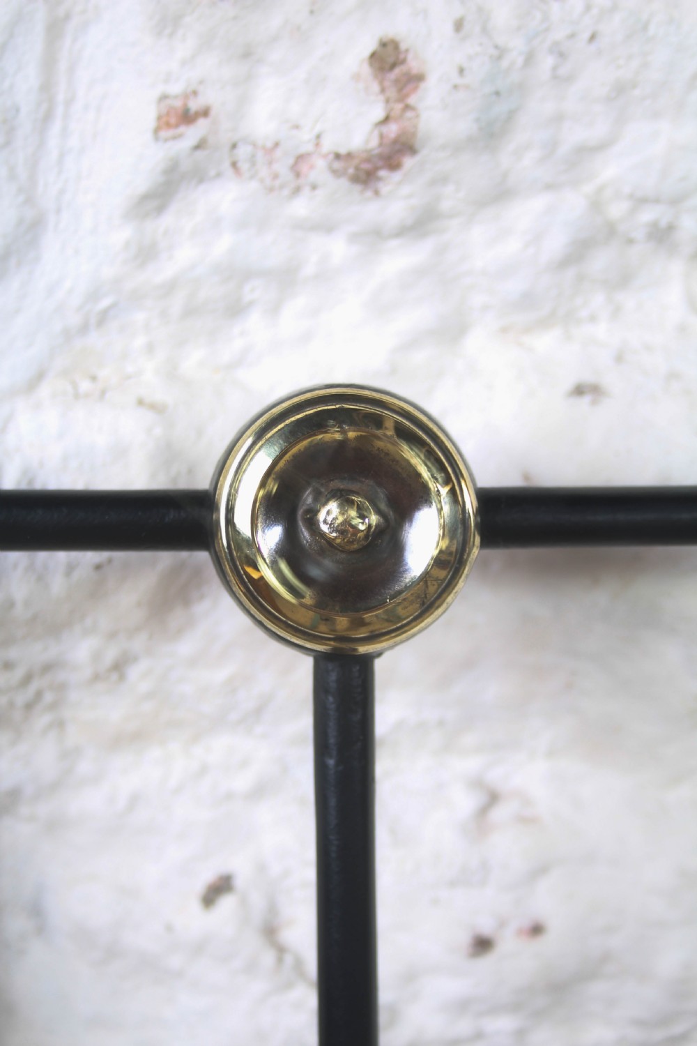 A king size black iron bed frame featuring a spindle headboard with brass roundels and a low foot end. View V