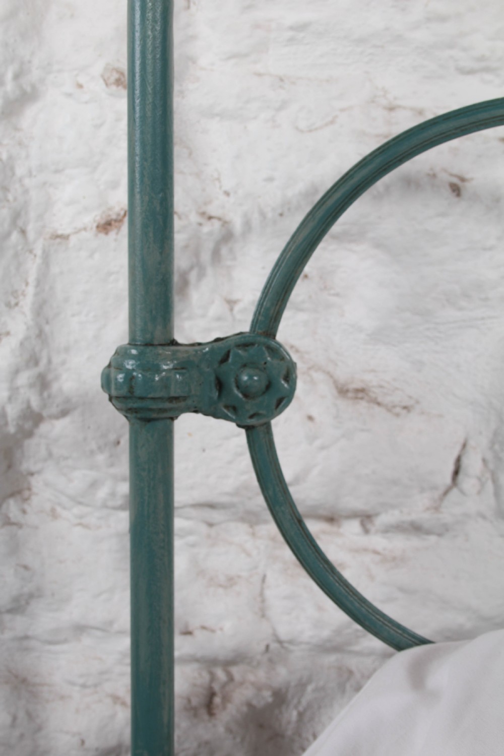 A pair of green painted iron single bed frames featuring scrolled Celtic heart motifs on the headboards and low open ends. View IV