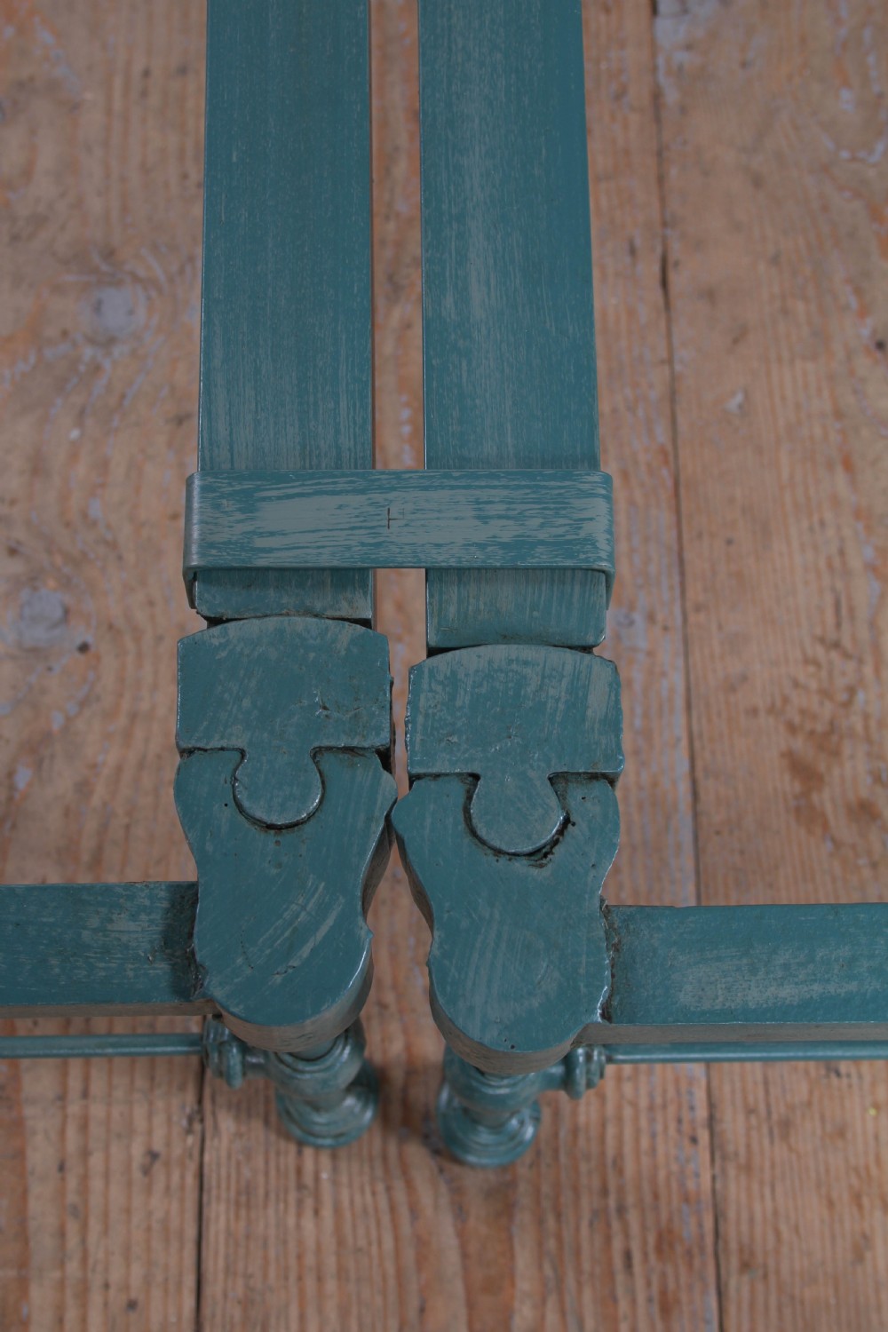 A pair of green painted iron single bed frames featuring scrolled Celtic heart motifs on the headboards and low open ends. View VII