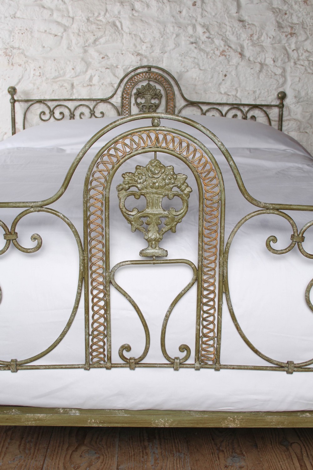 A king-size Portuguese wrought iron bed frame featuring an ornate arched headboard and footboard with central decorative medallions and a distressed green paint finish. View III