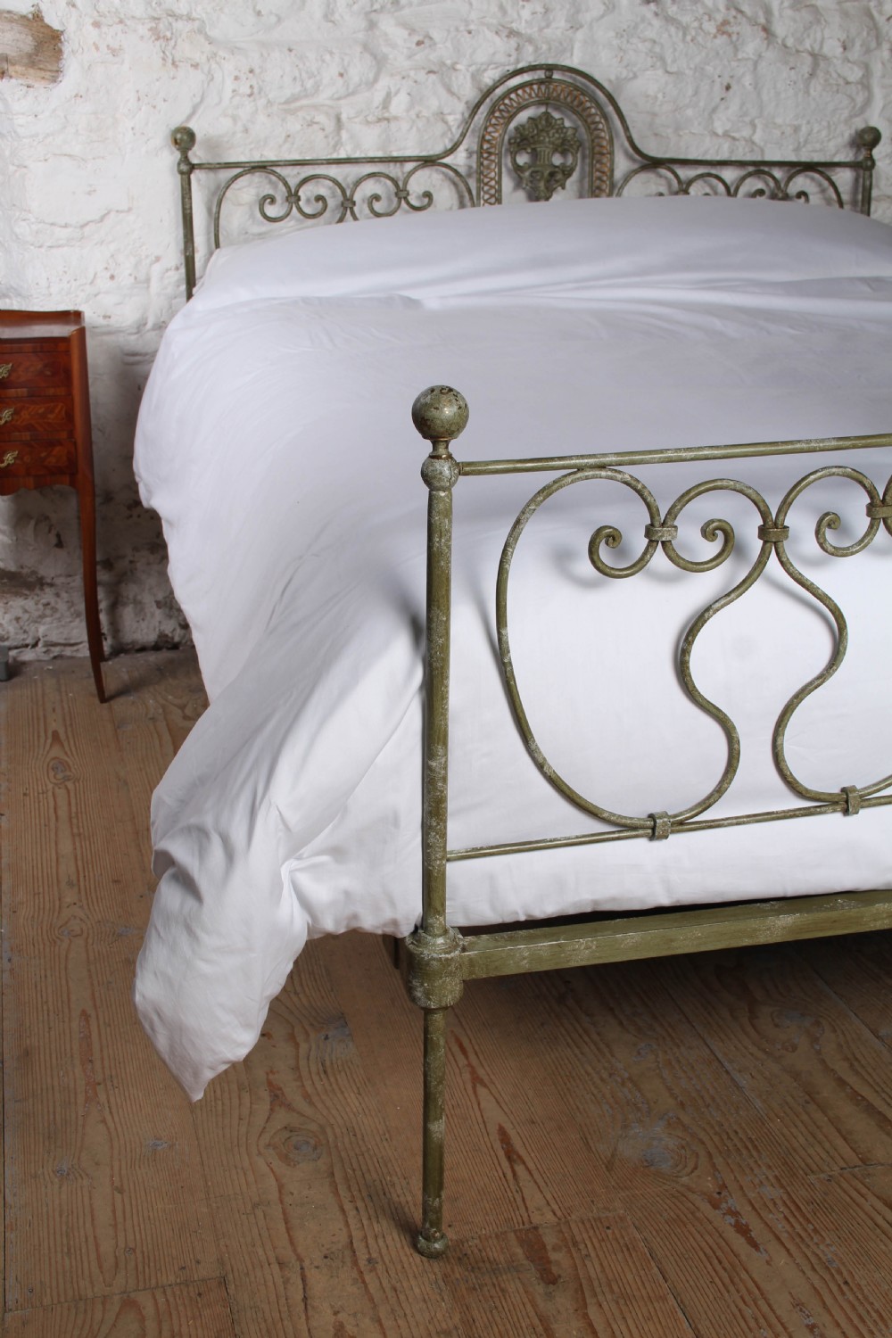 A king-size Portuguese wrought iron bed frame featuring an ornate arched headboard and footboard with central decorative medallions and a distressed green paint finish. View IV