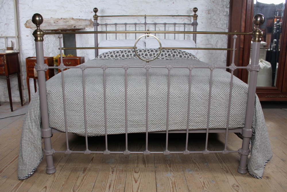 A Victorian cast iron and brass king size bedstead featuring vertical spindles, decorative brass finials, and a grey painted frame. View III
