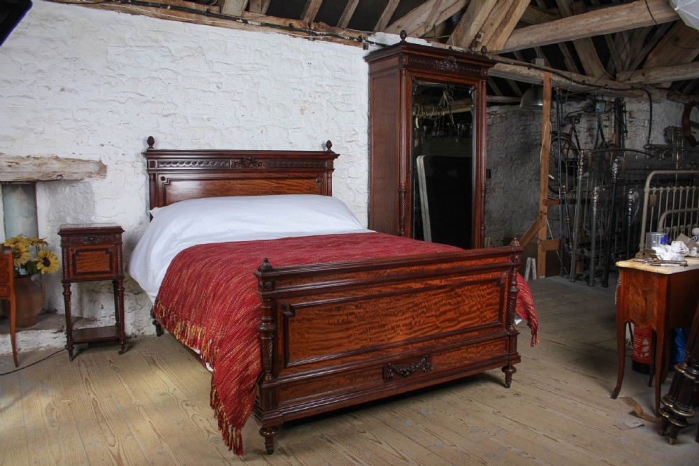 A French Louis XVI style carved mahogany king size bedstead with flame mahogany panelled footboard. View II