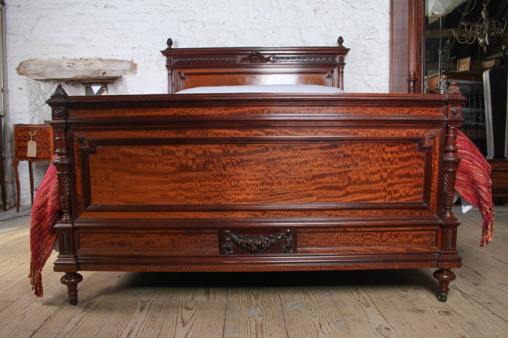 A French Louis XVI style carved mahogany king size bedstead with flame mahogany panelled footboard. View III