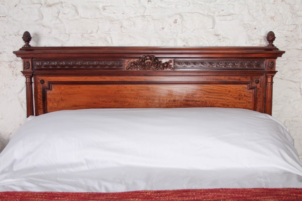 A French Louis XVI style carved mahogany king size bedstead with flame mahogany panelled footboard. View IV