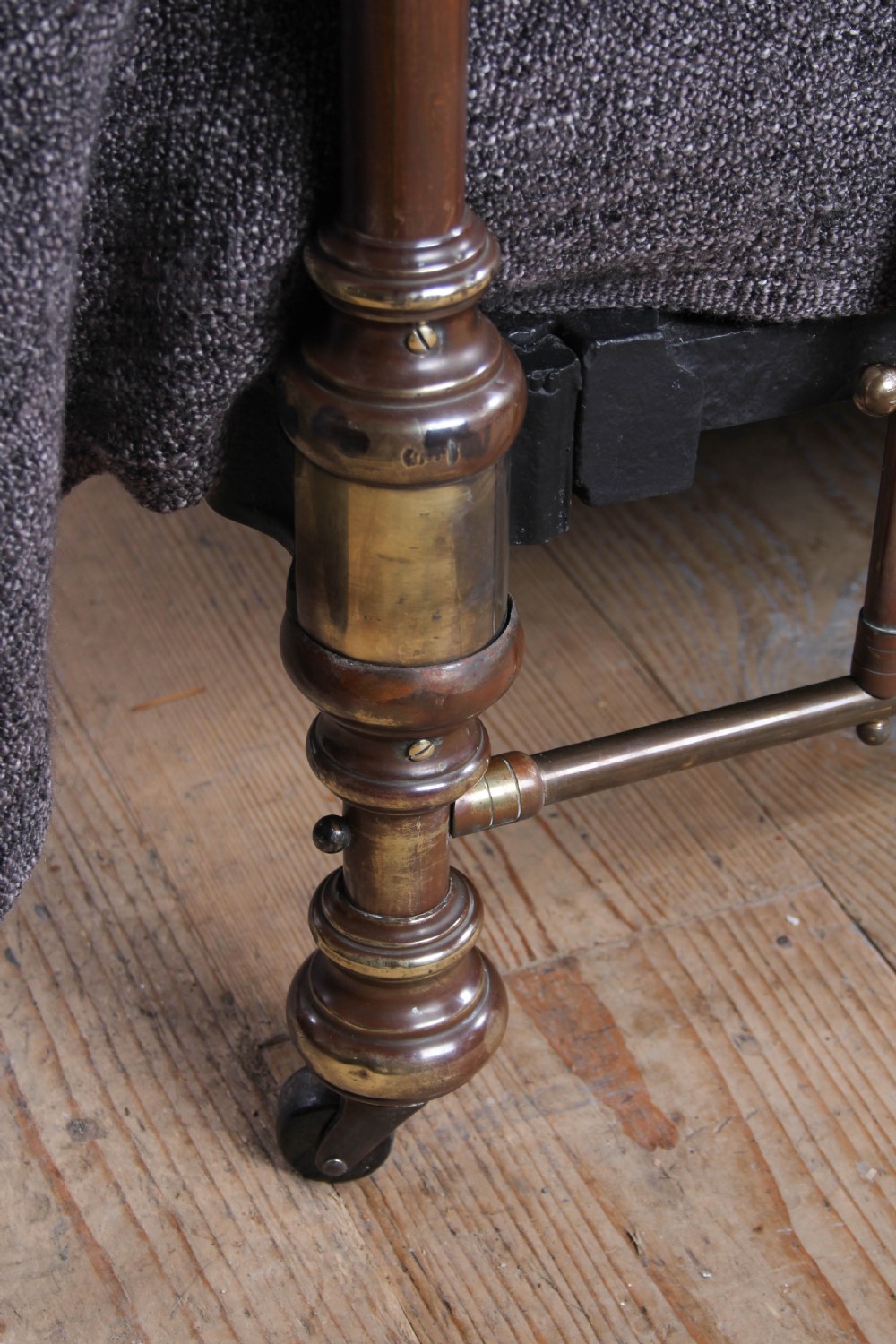A king-size French brass bedstead featuring vertical metal spindles topped with circular ring motifs and decorative urn finials on four corner posts. View V