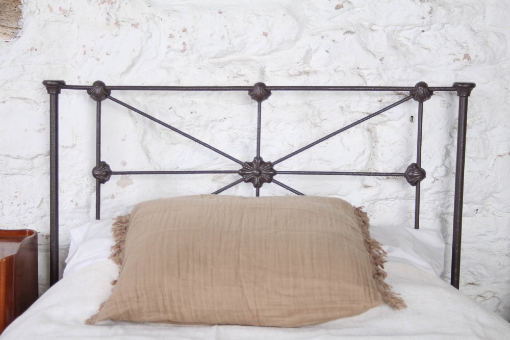 A pair of dark Victorian wrought iron single beds with geometric headboards and footless frames. View III