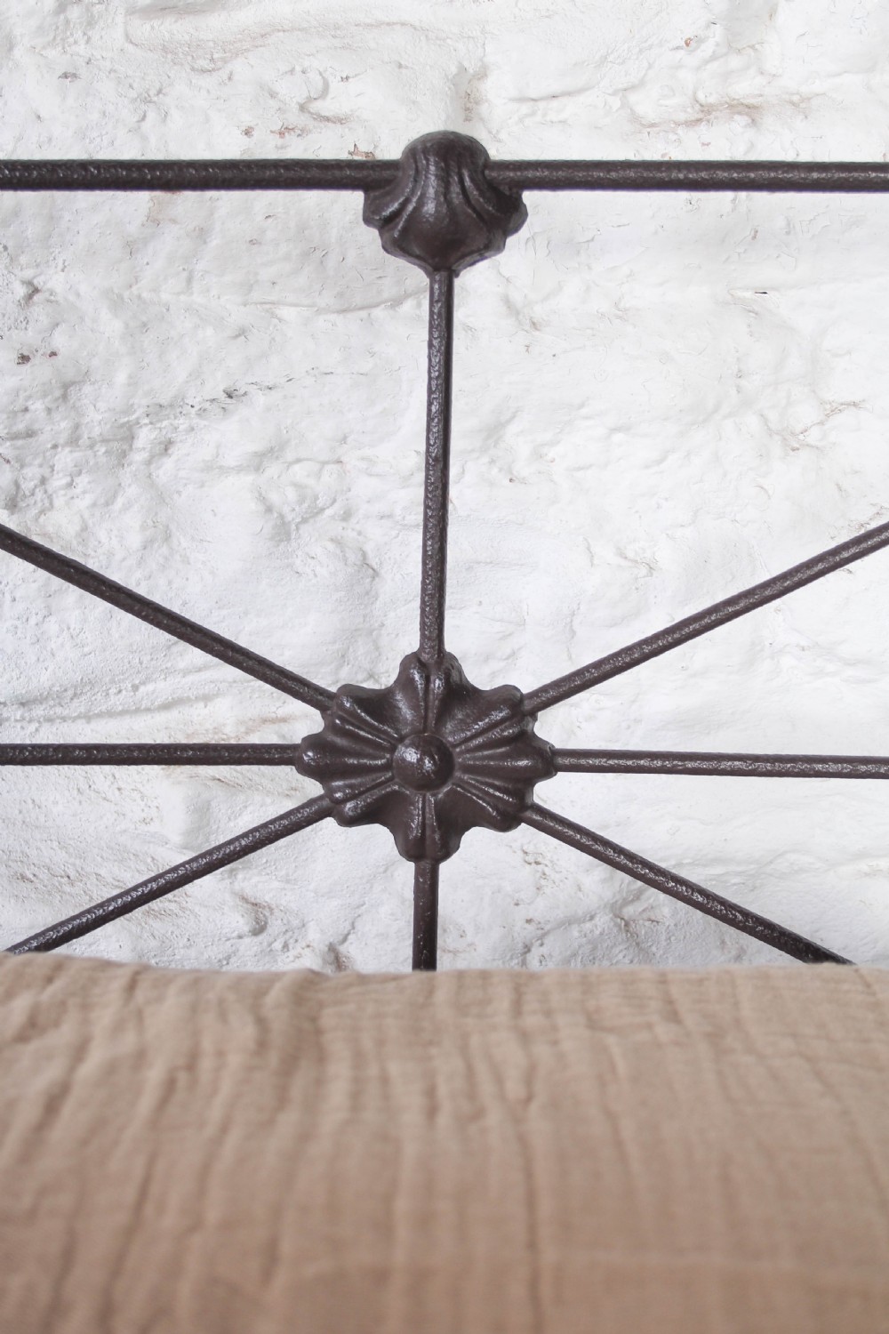 A pair of dark Victorian wrought iron single beds with geometric headboards and footless frames. View VII