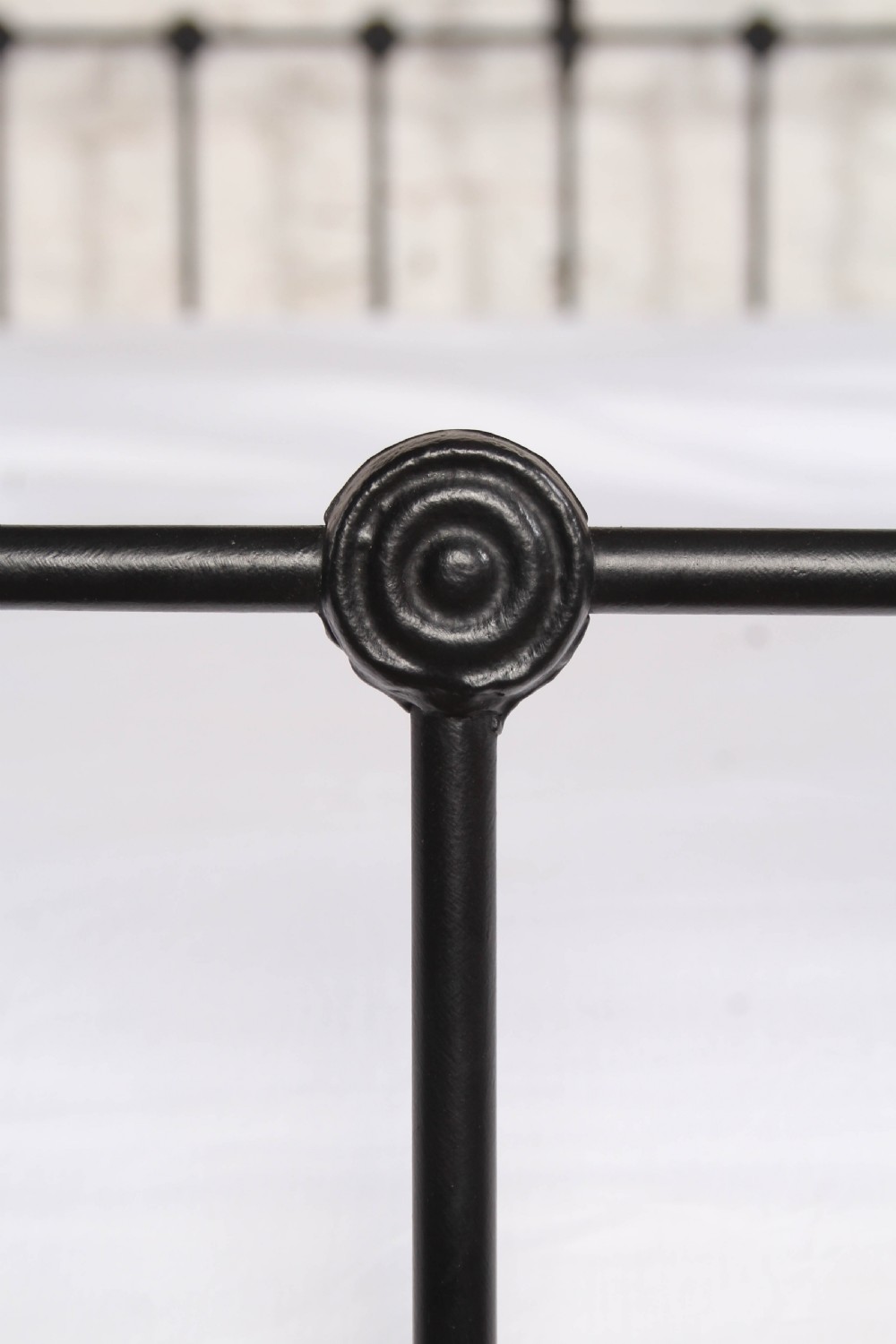 A Victorian black iron bedstead featuring vertical metal spindles, brass top rails, and round brass finials. View VIII