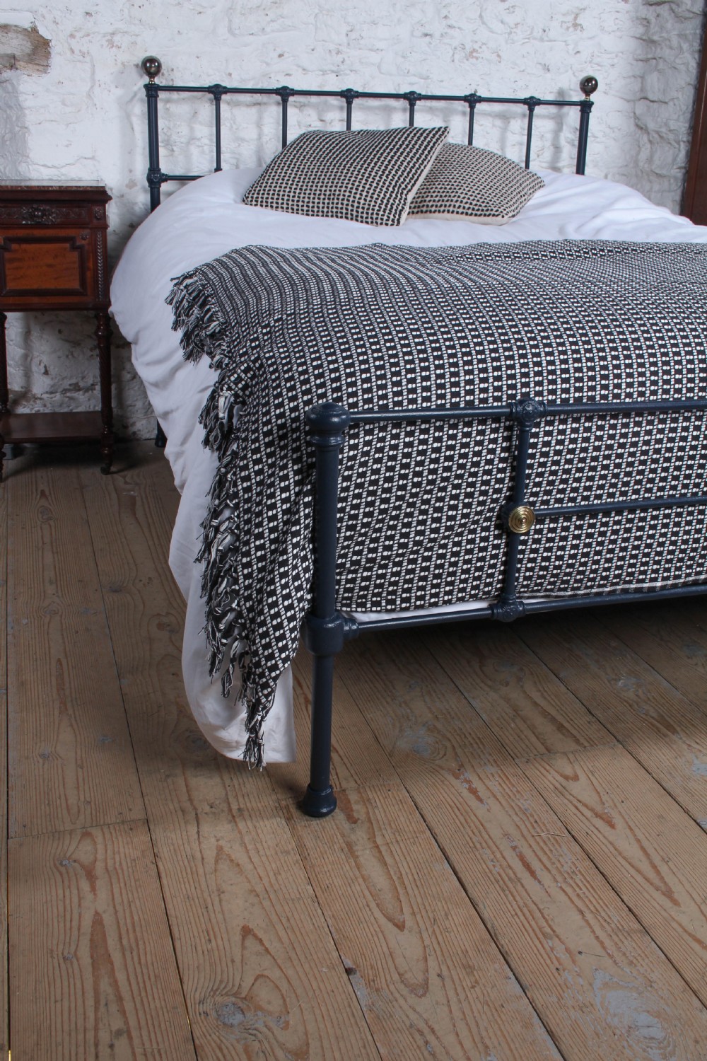 A Victorian style king size dark blue cast iron bedstead featuring decorative brass finials and a low footboard. View V