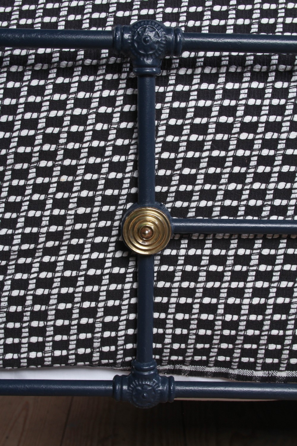 A Victorian style king size dark blue cast iron bedstead featuring decorative brass finials and a low footboard. View VI