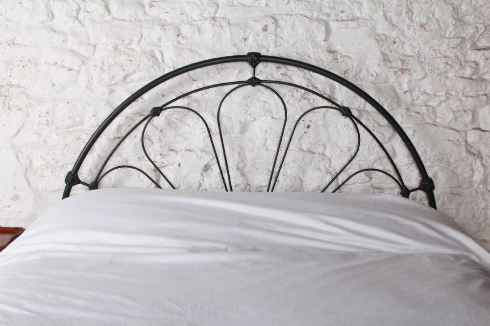 A Victorian black wrought iron king-size bed frame featuring an arched headboard with decorative scrollwork loops and a low footboard. View II