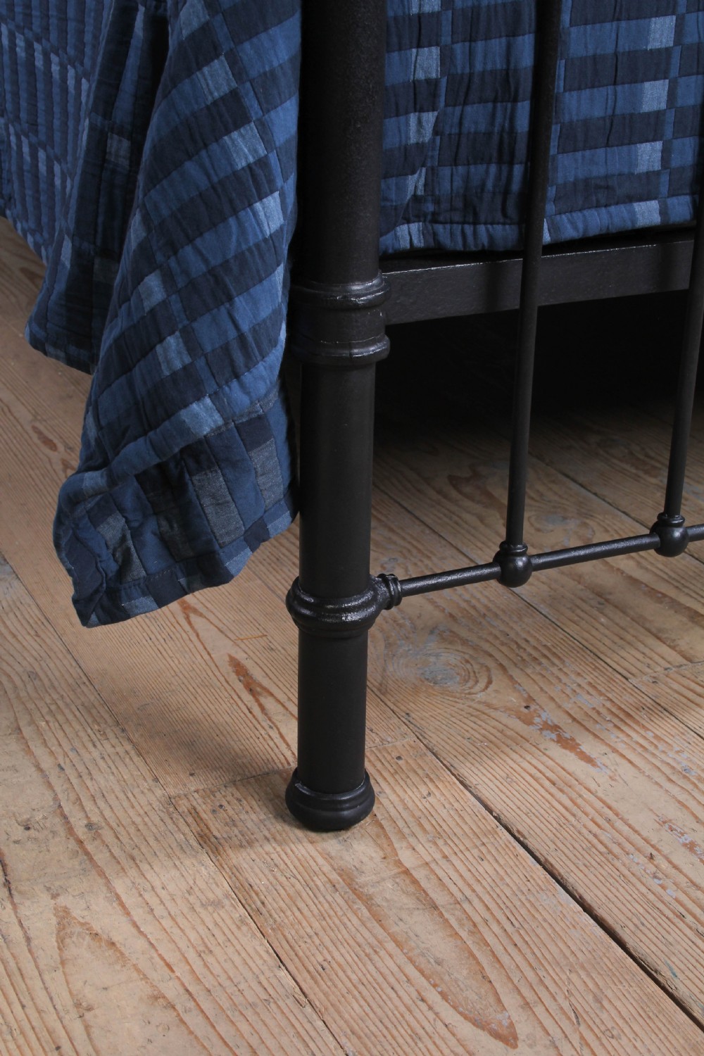 An Edwardian black iron and brass king-size bedstead featuring a curved dip rail and brass corner finials. View VII