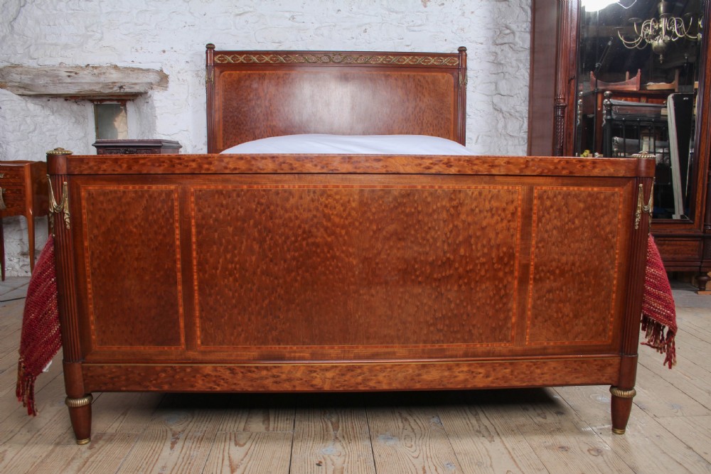 An antique French mahogany king-size bed frame featuring inlaid wood borders, decorative brass mounts, and fluted corner posts. View IV