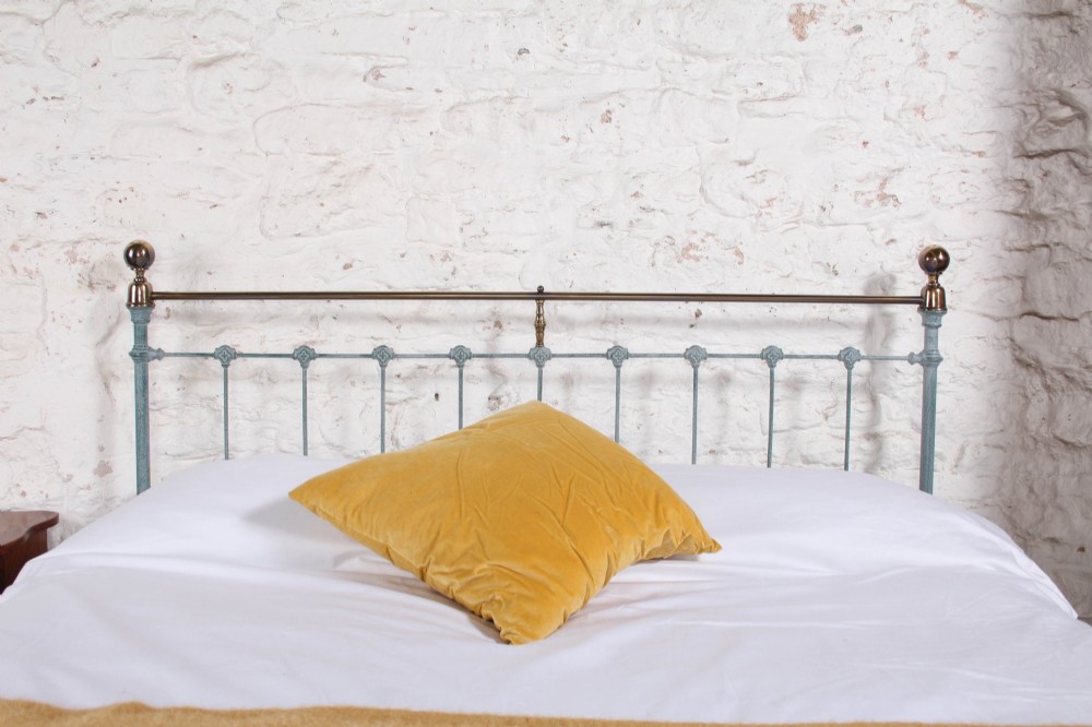A Victorian king-size light blue painted iron bedstead featuring a straight brass top rail with polished brass corner finials. View II