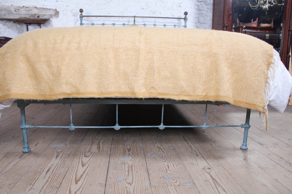A Victorian king-size light blue painted iron bedstead featuring a straight brass top rail with polished brass corner finials. View V