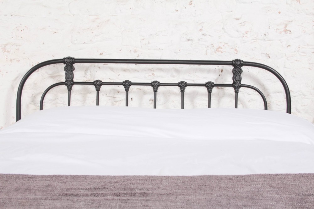 A Victorian Art Nouveau style black cast iron king size bed frame featuring vertical spindles and decorative joinery details. View III