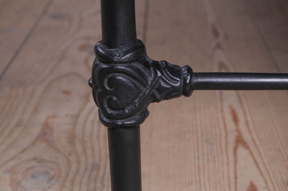A Victorian Art Nouveau style black cast iron king size bed frame featuring vertical spindles and decorative joinery details. View IV